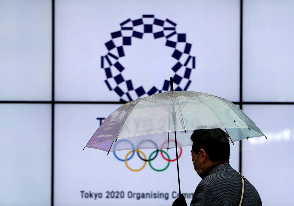 A man wearing a protective face mask walks past in front of a display showing the logo of Tokyo 2020 Olympic Games that have been postponed to 2021 due to Covid-19, in Tokyo, Japan January 23, 2021. u00e2u20acu201d Reuters pic 