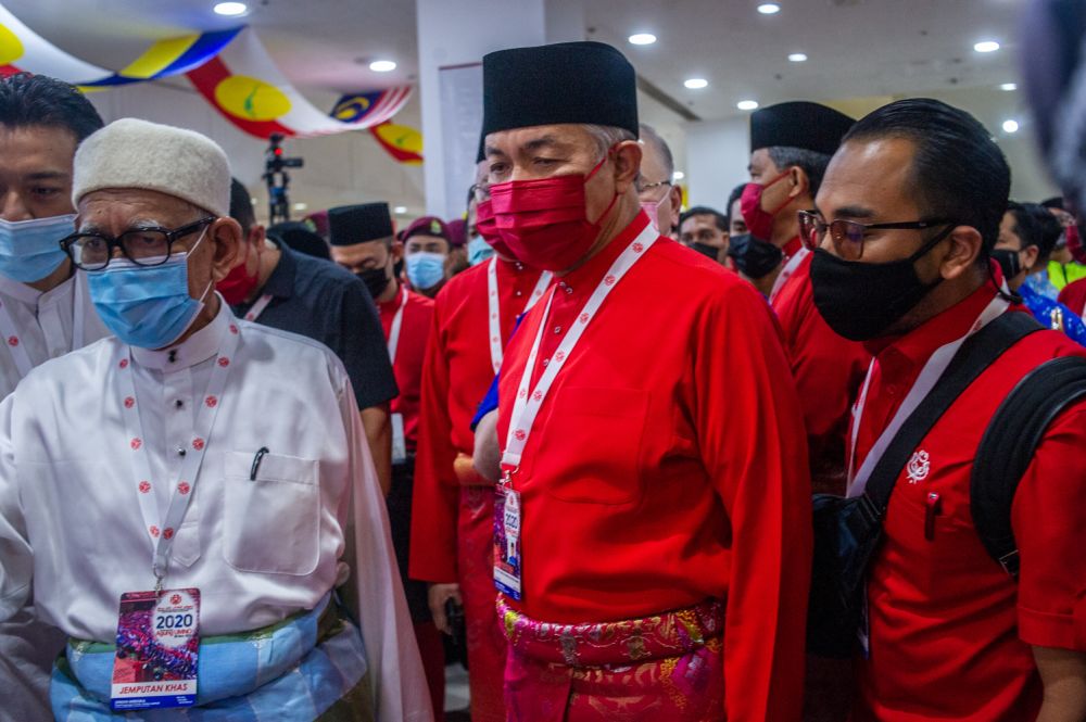 Umno president Datuk Seri Ahmad Zahid Hamidi (centre) arrives for the 2020 Umno general assembly in Kuala Lumpur March 28, 2021. u00e2u20acu201d Picture by Shafwan Zaidon