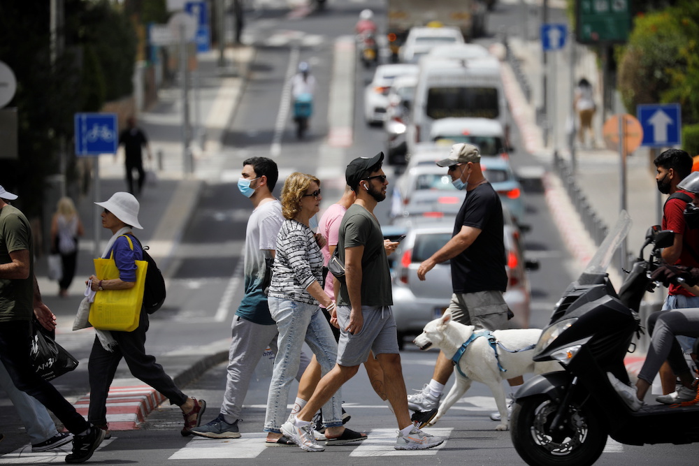 Pedestrians cross a street as Israel rescinds the mandatory wearing of face masks outdoors in the latest return to relative normality, boosted by a mass-vaccination campaign, in Tel Aviv, Israel April 18, 2021. u00e2u20acu201d Reuters pic