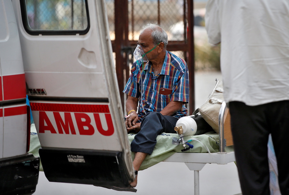 A patient wearing an oxygen mask sits on a bed as he is being shifted to a hospital for treatment, amidst the spread of the coronavirus disease (Covid-19) in Ahmedabad, India April 15, 2021. u00e2u20acu201d Reuters pic