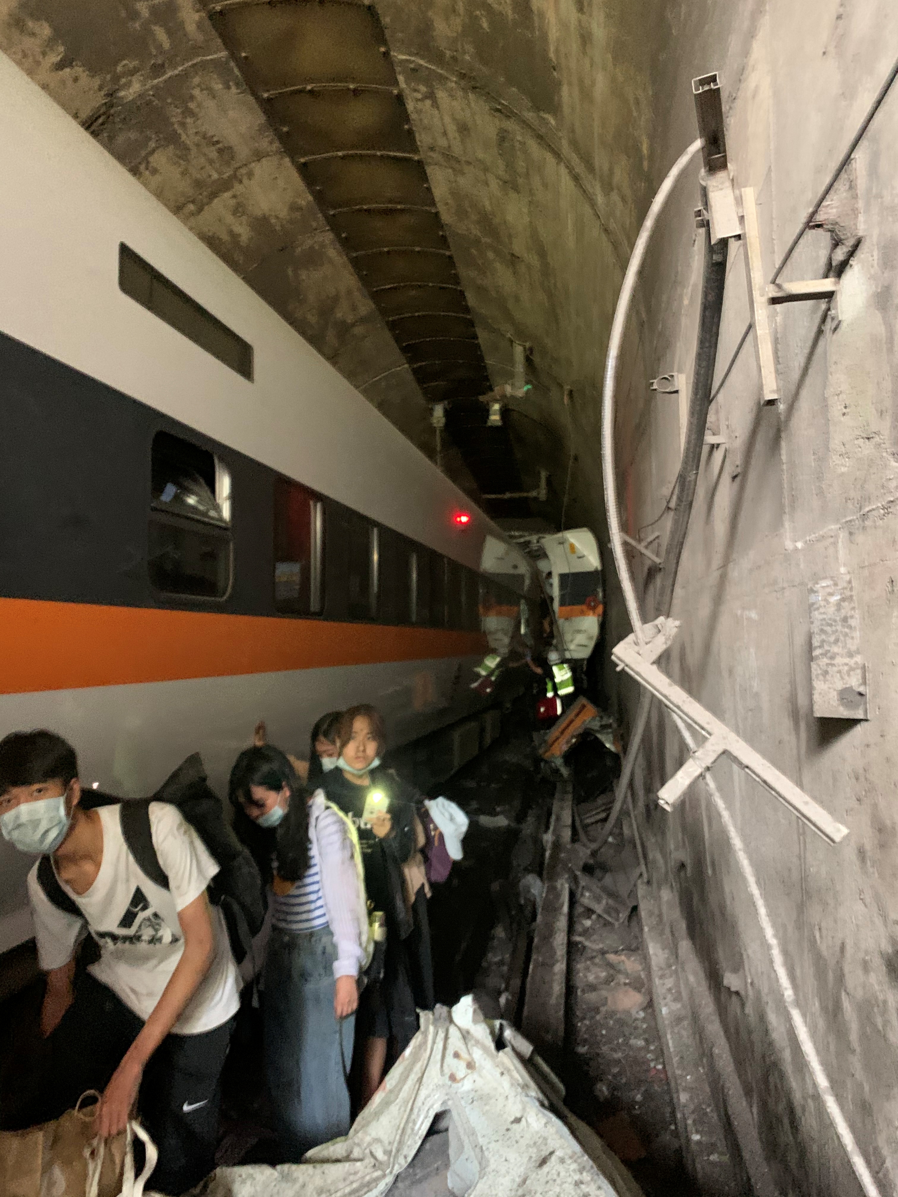 列车第3节至第8节车厢受困隧道中，民众摸黑逃离隧道。-路透社-