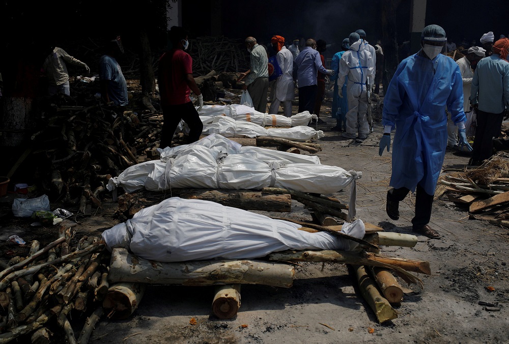 A health worker wearing PPE walks past the funeral pyres of those who died from the coronavirus disease during a mass cremation at a crematorium in New Delhi April 26, 2021. u00e2u20acu201d Reuters pic
