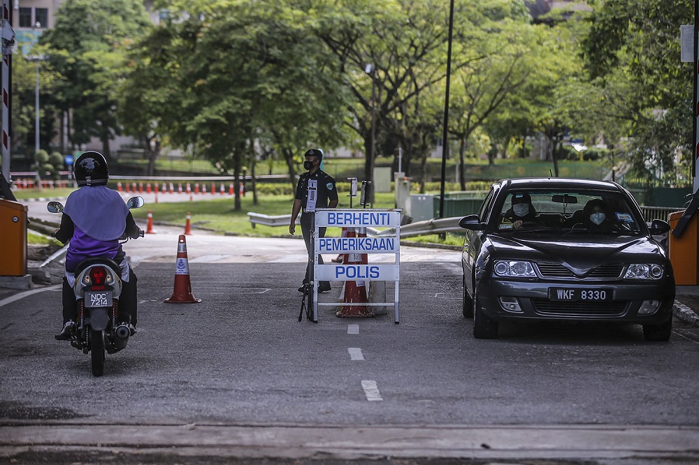 Police personnel man the main entrance of the International Islamic University Malaysia in Gombak April 1, 2021. u00e2u20acu201d Picture by Hari Anggara