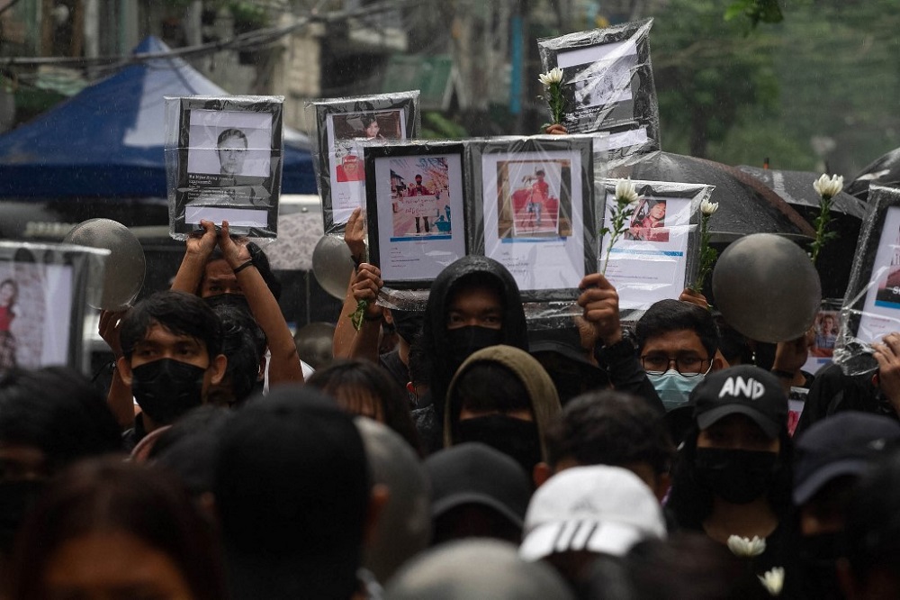 This photo taken and received from an anonymous source via Facebook April 5, 2021 shows protesters holding up portraits of people who have died while taking part in the demonstrations against the military coup, at a rally in Yangon. u00e2u20acu201d Handout via AFP