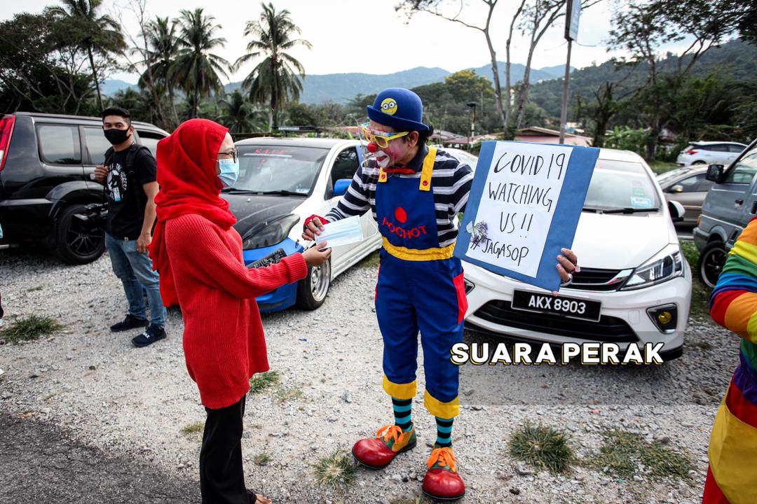 小丑在斋戒月市集入口处派发免费口罩！-图摘自Suara Perak-