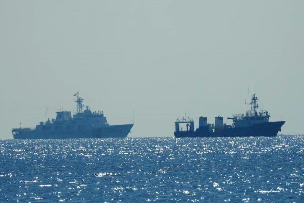 A Chinese Coast Guard patrol ship (left) is seen near an unidentified vessel at South China Sea, in a handout photo distributed by the Philippine Coast Guard April 15 and taken according to the source either on April 13 or 14, 2021. u00e2u20acu201d Reuters pic