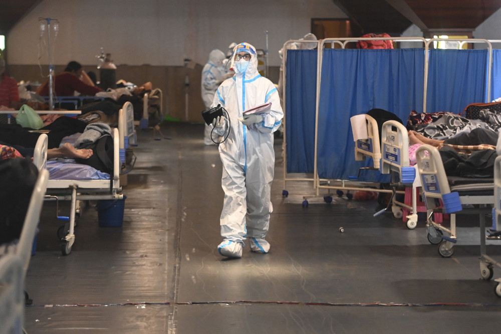 A health worker wearing a personal protective equipment (PPE) kit walks inside a banquet hall temporarily converted into a Covid-19 coronavirus ward in New Delhi April 27, 2021. u00e2u20acu201d AFP picnn