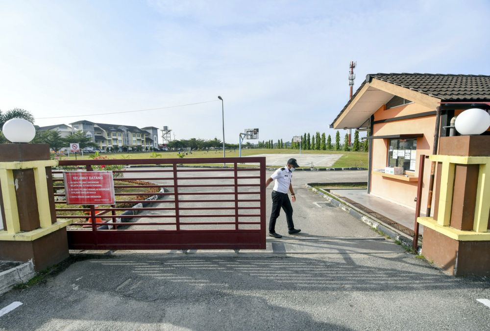 A security guard at Sekolah Menengah Kebangsaan Padang Enggang closes the school gate in Kota Bharu April 18, 2021. u00e2u20acu201d Bernama pic