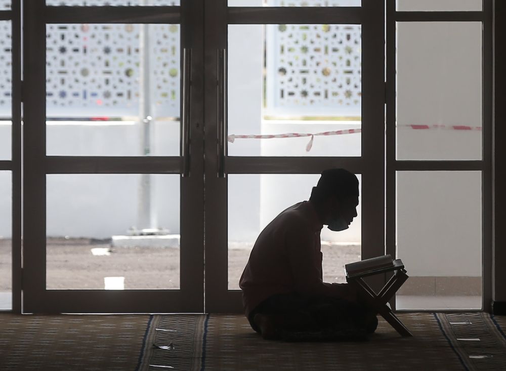 A man reads the al-Quran during the fasting month of Ramadan at Masjid Jamek Idris Iskandar Shah 1 in Ipoh April 19, 2021. u00e2u20acu201d Picture by Farhan Najib