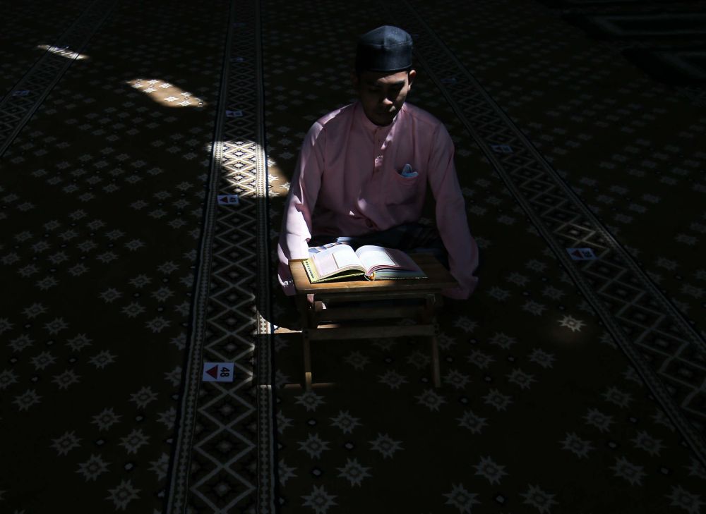 A man reads the al-Quran during the fasting month of Ramadan at Masjid Jamek Idris Iskandar Shah 1 in Ipoh April 19, 2021. u00e2u20acu201d Picture by Farhan Najib