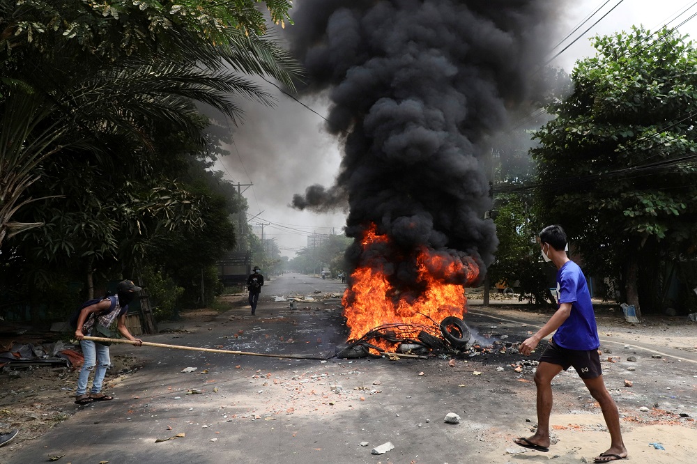 An anti-coup protester walks past burning tires after activists launched a u00e2u20acu02dcgarbage strikeu00e2u20acu2122 against the military rule, in Yangon, Myanmar March 30, 2021. u00e2u20acu2022 Reuters pic
