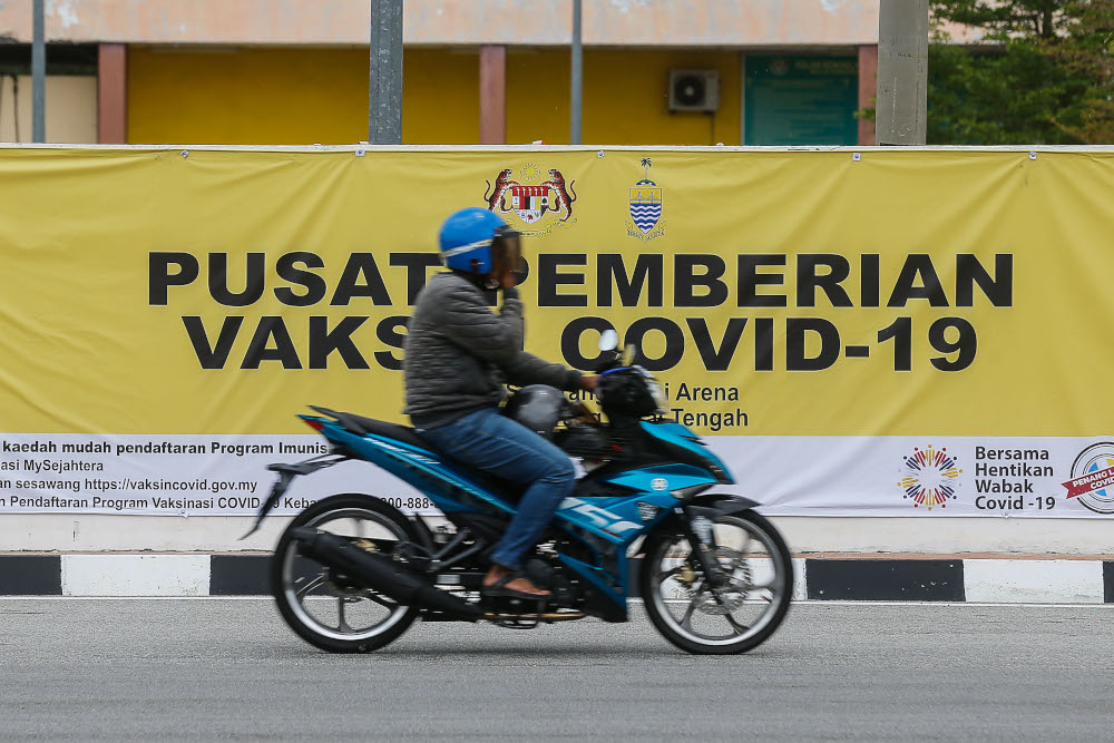 A motorist rides past the Vaccine Administration Centre banner in Seberang Perai Arena, Seberang Jaya April 2, 2021. u00e2u20acu201d Picture by Sayuti Zainudin