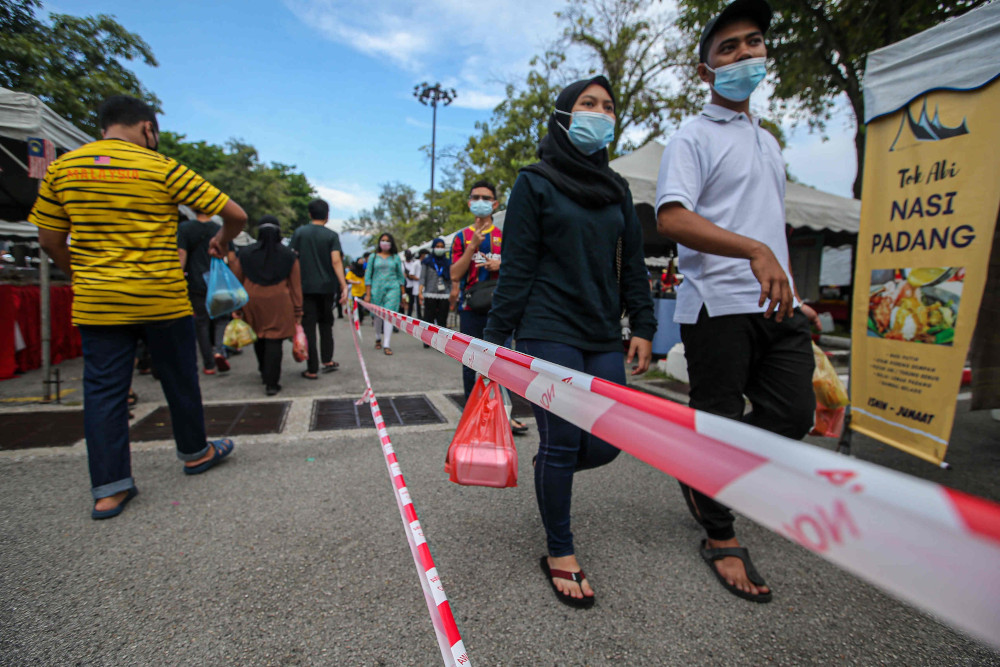 People in Ipoh follow the standard operating procedures (SOP) while purchasing their favourite delicacies at the Ramadan bazaar at Stadium Indera Mulia Car Park, April 15, 2021. u00e2u20acu201d Picture by Farhan Najib