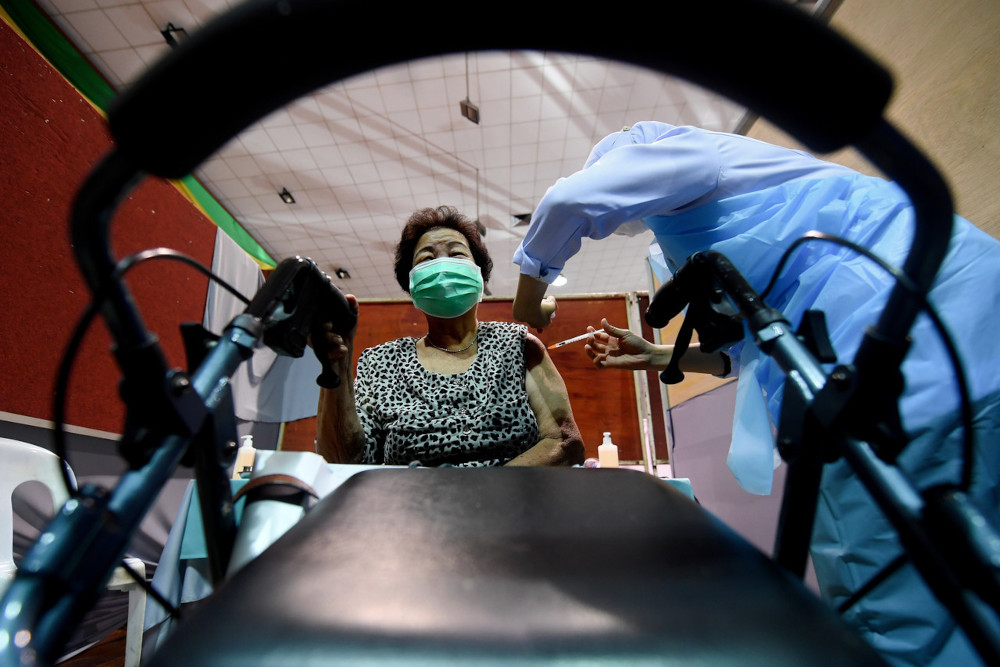 Senior citizen Yuen Mee Van, 81, receiving a Covid-19 jab during the Phase 2 Vaccination programme at the Sandakan Community Hall in Sabah, April 19, 2021. u00e2u20acu201d Bernamann