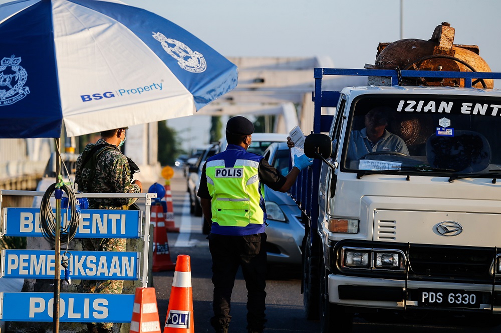 Police personnel inspect vehicles at a roadblock along Jambatan Merdeka, at the Kedah-Penang border  May 10, 2021. u00e2u20acu201d Picture by Sayuti Zainudin