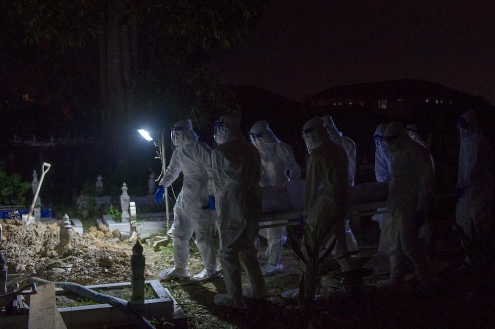 Health workers in personal protective equipment prepare to bury the body of a Covid-19 victim at the Muslim cemetery in Kampung Changkat Gombak, Kuala Lumpur May 30, 2021. u00e2u20acu201dPicture by Shafwan Zaidonn