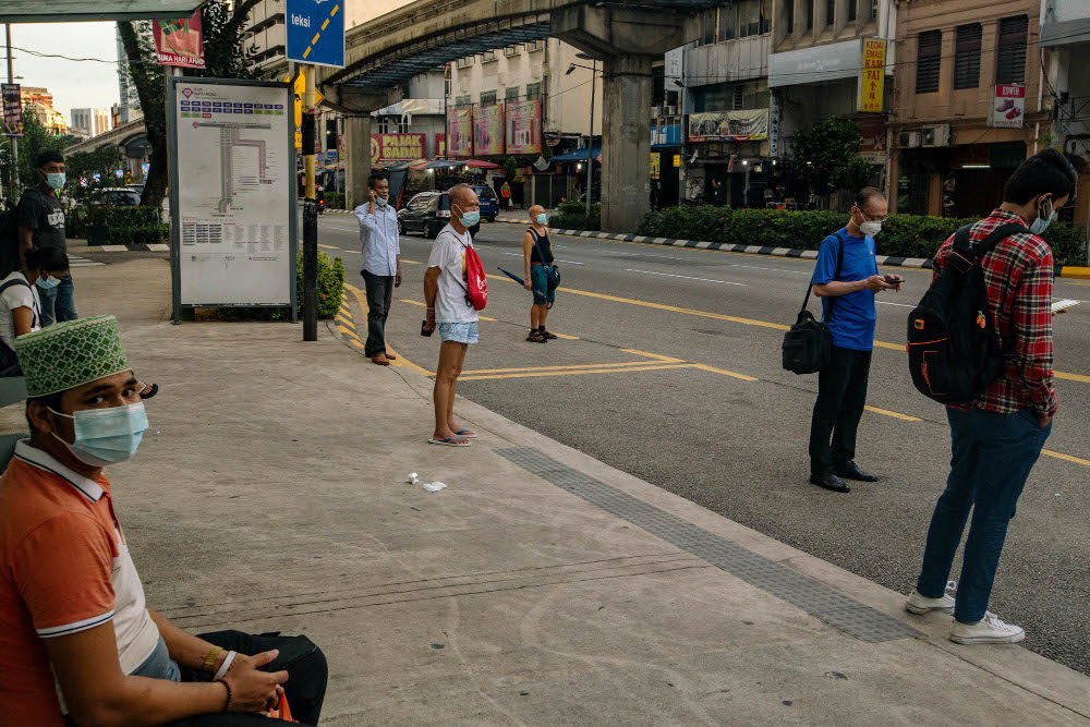 People wearing face masks as a precaution against the spread of Covid-19 wait for a bus in Kuala Lumpur May 31, 2021. u00e2u20acu201d Picture by Firdaus Latif