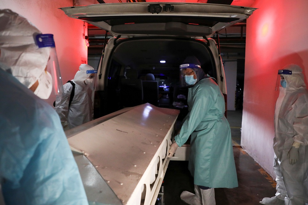 Malaysian Muslim cleric Rafie Zainal and his team members move a body of a Covid-19 victim to a van before burial at a hospital mortuary, in Kuala Lumpur May 23, 2021. u00e2u20acu2022 Reuters pic