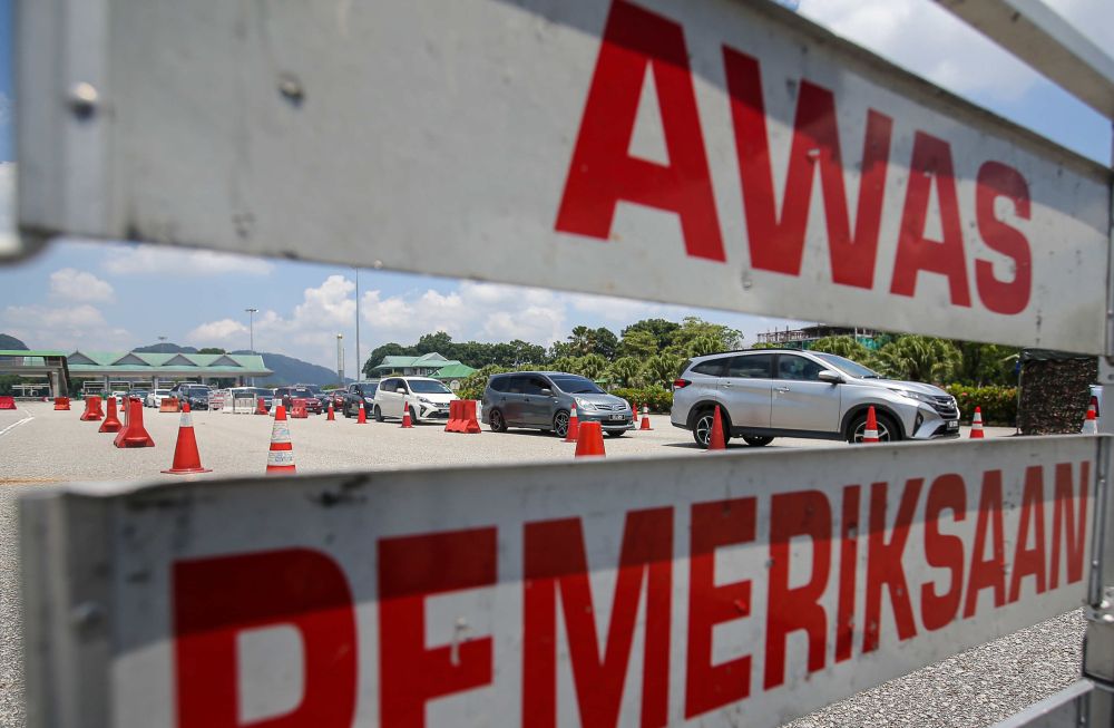 Vehicles are stopped for inspection at a roadblock during MCO 3.0 at the Ipoh Selatan Toll May 10, 2021. u00e2u20acu201d Picture by Farhan Najib