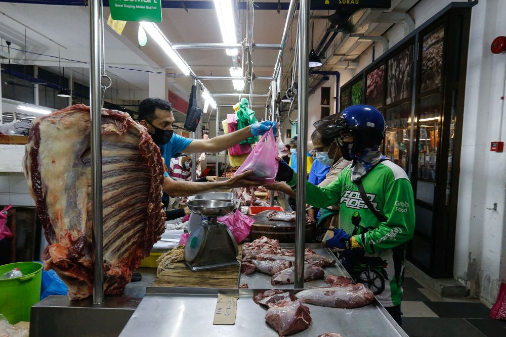 今年5月11日，GrabFood外送员到乔治市的百年巴刹“吉灵万山”（Chowrasta Market）领取顾客购买的杂货。- Sayuti Zainudin摄-