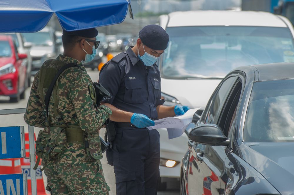 Police and Armed Forces personnel conduct checks on vehicles at a roadblock at the KL-Seremban Highway in Kuala Lumpur May 25, 2021. u00e2u20acu201d Picture by Shafwan Zaidonnn