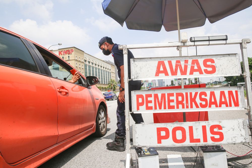 Police conduct checks on vehicles at a roadblock on the Federal Highway on the first day of Raya May 13, 2021. u00e2u20acu201d Picture by Choo Choy May