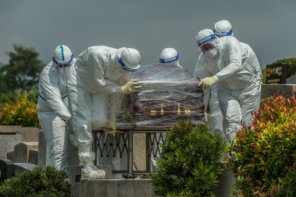 Workers in PPE suits carry the body of a person who died from the coronavirus disease (Covid-19) at a Christian cemetery in Semenyih, Selangor. u00e2u20acu201d Picture by Shafwan Zaidon