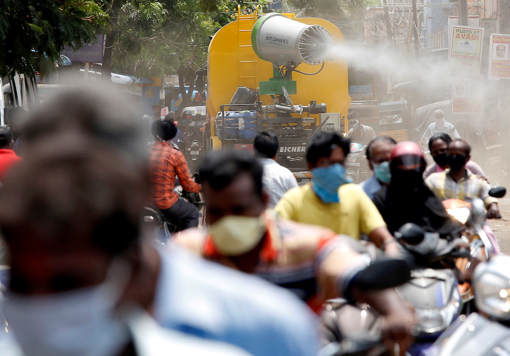 People wearing face masks ride motorcycles as a municipal vehicle decontaminates a road during a 21-day nationwide lockdown to slow the spreading of coronavirus disease, in Chennai  India, April 9, 2020. u00e2u20acu2022 Reuters picnn