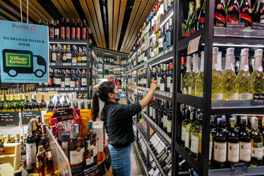 Staff arranging bottles of alcohol at Village Grocer in Bangsar, Kuala Lumpur, June 4, 2021. u00e2u20acu201d Picture by Firdaus Latif