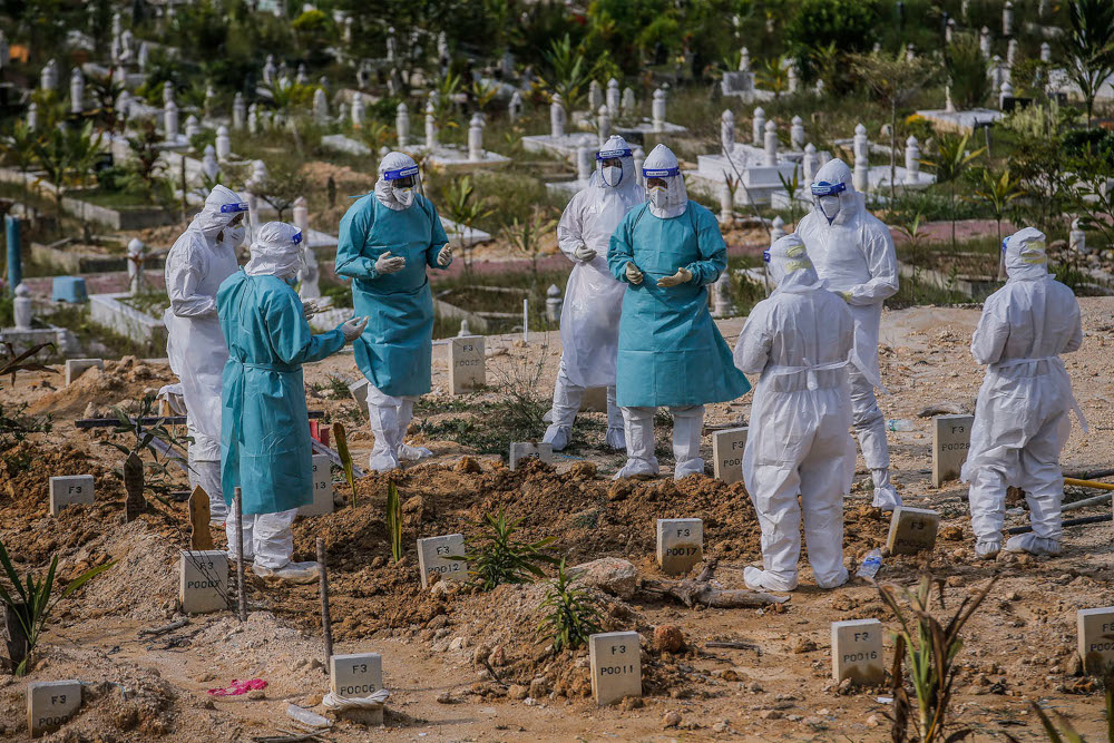 Workers wearing personal protective equipment recite a prayer after burying a person who died from Covid-19 at the Muslim cemetery in Gombak June 8, 2021. u00e2u20acu2022 Picture by Hari Anggara