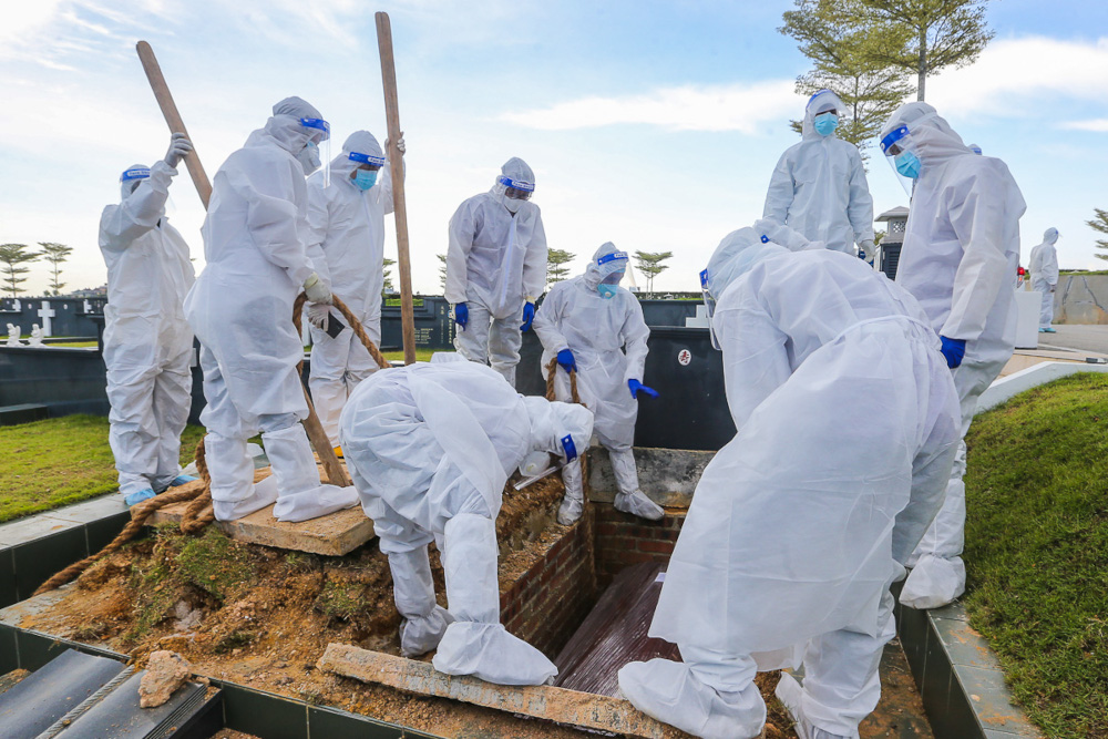 Workers wearing personal protective equipment bury a person who died from Covid-19 at the Christian cemetery in Fairy Park, Klang June 6, 2021. u00e2u20acu201d Picture by Yusof Mat Isa