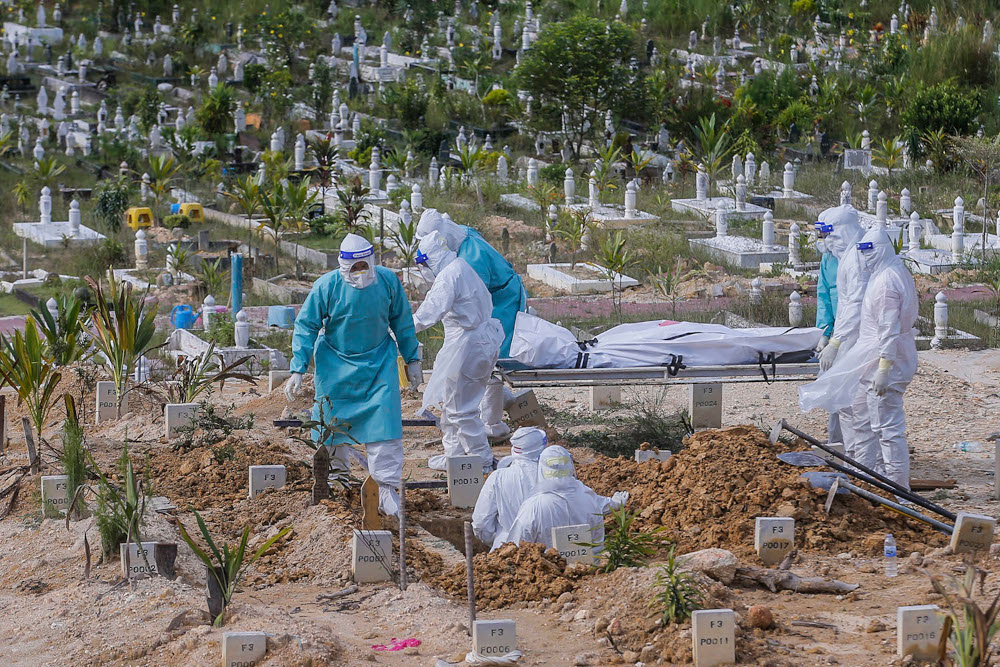 Workers in personal protective equipment prepare to bury the body of a Covid-19 victim at the Muslim cemetery in Gombak June 8, 2021. u00e2u20acu2022 Picture by Hari Anggara