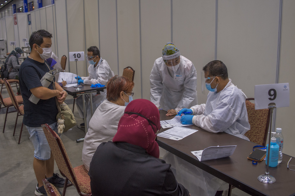 Vaccine recipients receiving consultation with a health practitioner during the National Covid-19 Immunisation Programme at Kuala Lumpur Convention Centre in Kuala Lumpur June 8, 2021. u00e2u20acu201d Picture by Shafwan Zaidon