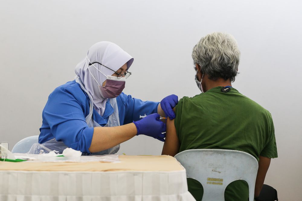 A nurse administers the second dose of Covid-19 vaccine to the homeless at Anjung Kelana, Kuala Lumpur June 17, 2021.  u00e2u20acu2022 Picture by Yusof Mat Isa