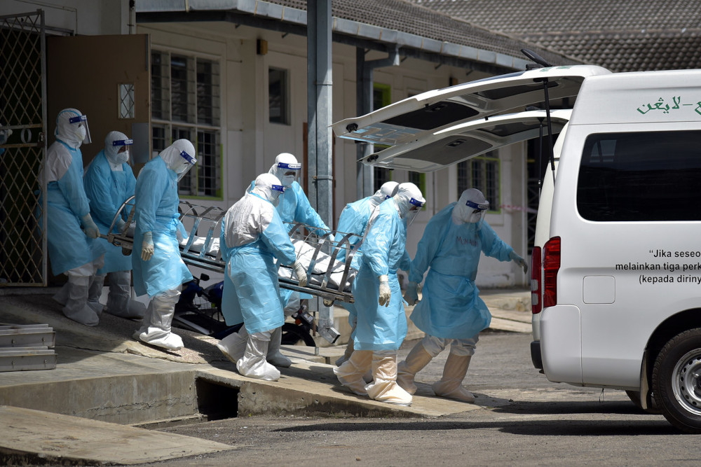 Health personnel transport the remains of a Covid-19 patient for burial at the Labuan Nucleus Hospital, June 7, 2021. u00e2u20acu201d Bernama pic 