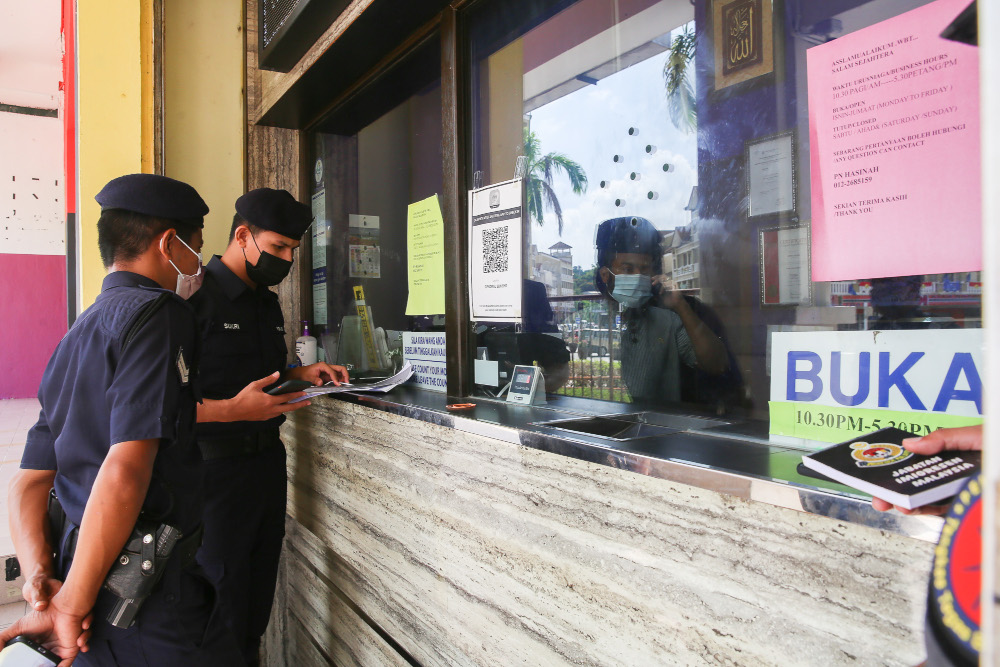 Enforcement officers (Police, Immigration and Army) checking the standard operating procedure (SOP) compliance at shops in Putrajaya, June 14, 2021. u00e2u20acu201d Picture by Choo Choy May 
