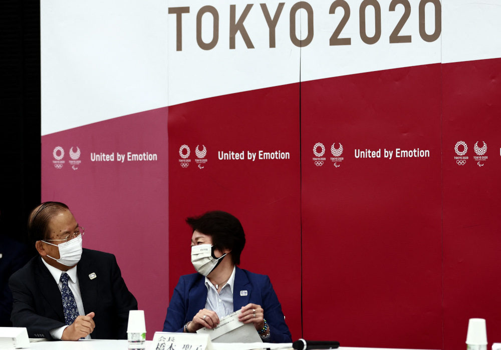 东京奥组委主席桥本圣子（右）和首席执行官武藤敏郎（左），在执委会会议上商议。-法新社-