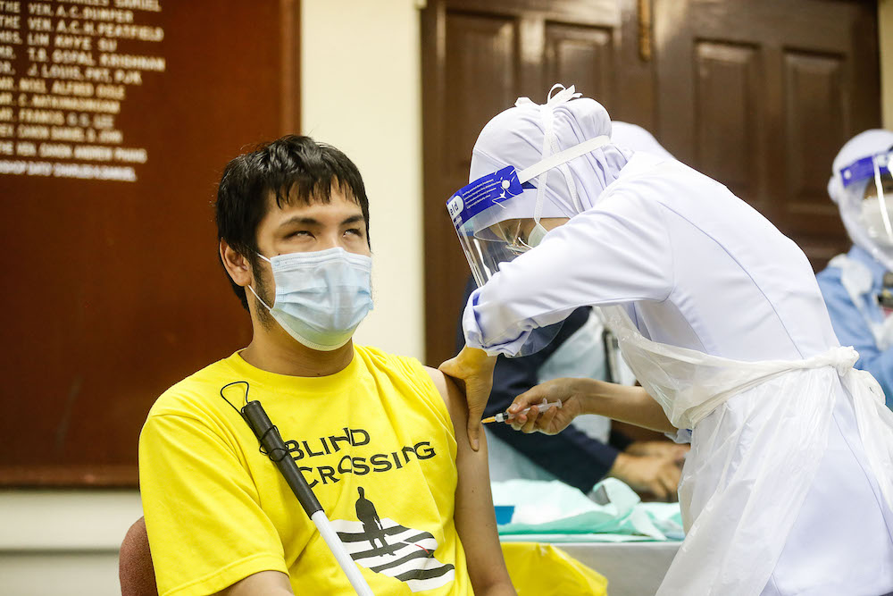 A nurse administers the vaccine to a disabled resident during the vaccination session for Persons with Disabilities in St Nicholas Home, Bagan Jermal July 5, 2021. u00e2u20acu201d Picture by Sayuti Zainudin