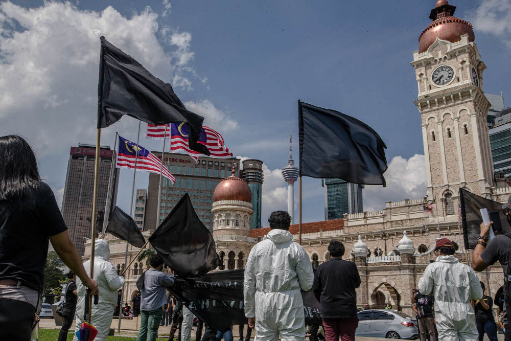 A group of youth wearing black shirts and personal protection equipment (PPE) wave black flags during a protest at Dataran Merdeka in Kuala Lumpur July 17, 2021. u00e2u20acu201d Picture by Firdaus Latif