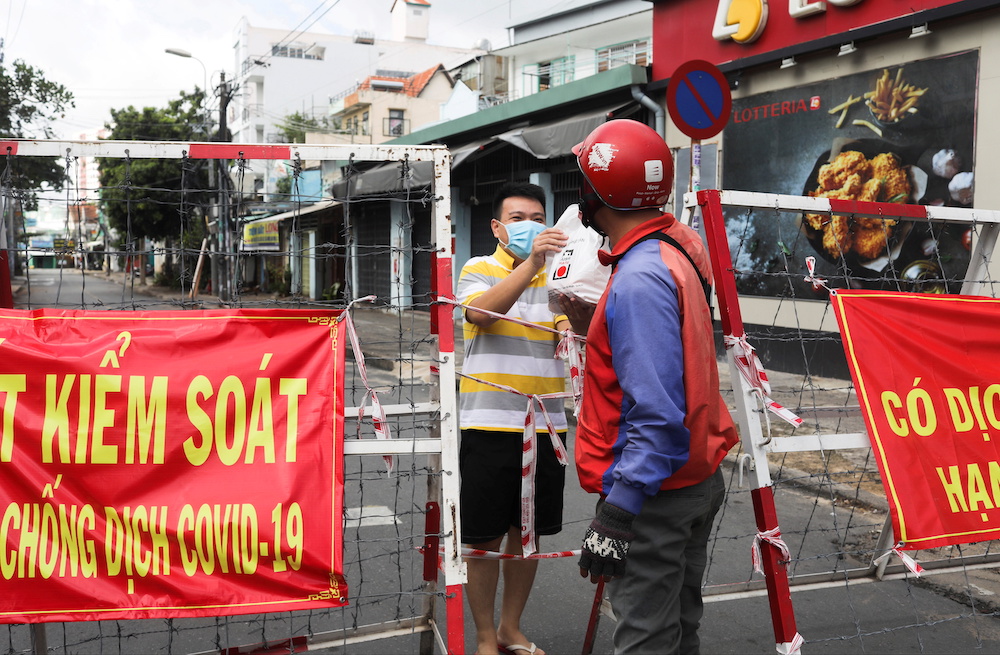 A man living in an area under lockdown receives food through a barricade during the Covid-19 pandemic in Ho Chi Minh City, Vietnam July 20, 2021. u00e2u20acu201d Reuters pic