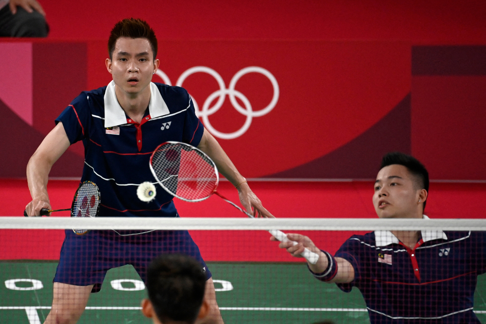 Malaysiau00e2u20acu2122s Aaron Chia hits a shot next to Soh Wooi Yik in their menu00e2u20acu2122s doubles badminton semi-final match against Chinau00e2u20acu2122s Liu Yuchen and Li Junhui at the Musashino Forest Sports Plaza in Tokyo July 30, 2021. u00e2u20acu201d AFP picnn