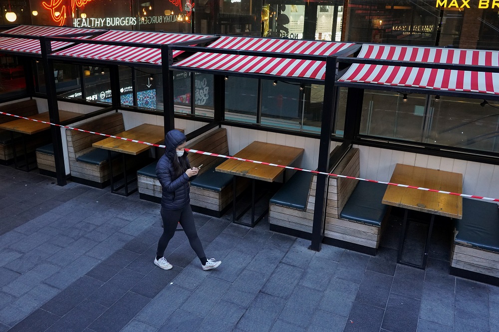 A woman wearing a protective mask walks past city centre restaurant tables closed to seating in accordance with public health regulations during a lockdown to curb the spread of Covid-19 in Sydney July 5, 2021. u00e2u20acu2022 Reuters pic