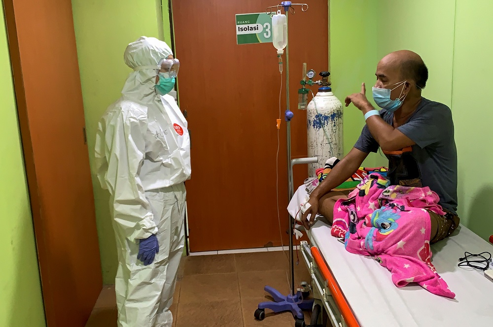 Cheras Sjarfi, a 28-year-old doctor, talks with a patient during her shift inside an isolation room at a government-run hospital, as Covid-19 cases surges in Jakarta July 1, 2021. u00e2u20acu2022 Reuters pic