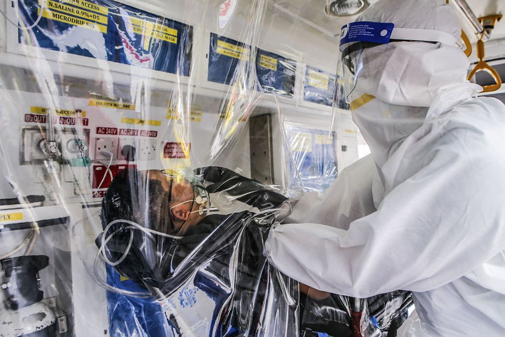 Paramedic Norsahril Abdul Razak, in full Personal Protection Equipment, demonstrates how a suspected Covid-19 case is handled in the repurposed ambulance. u00e2u20acu201d Picture by Hari Anggara