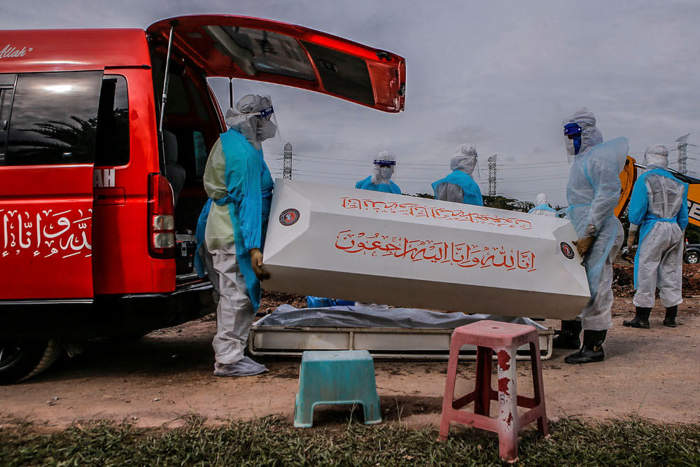 Health workers in personal protective equipment bury the body of a Covid-19 victim at the Muslim cemetery in Section 21, Shah Alam, July 10, 2021. u00e2u20acu2022 Picture by Hari Anggara