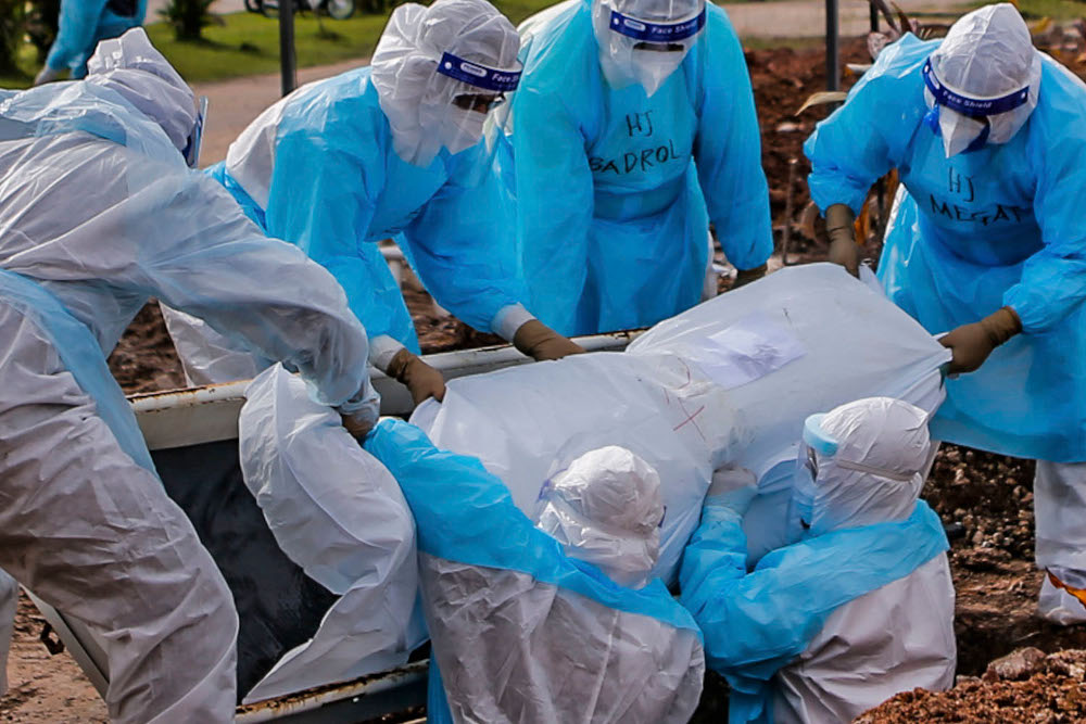 Health workers in personal protective equipment bury the body of a Covid-19 victim at the Muslim cemetery in Section 21, Shah Alam, July 10, 2021. u00e2u20acu2022 Picture by Hari Anggara