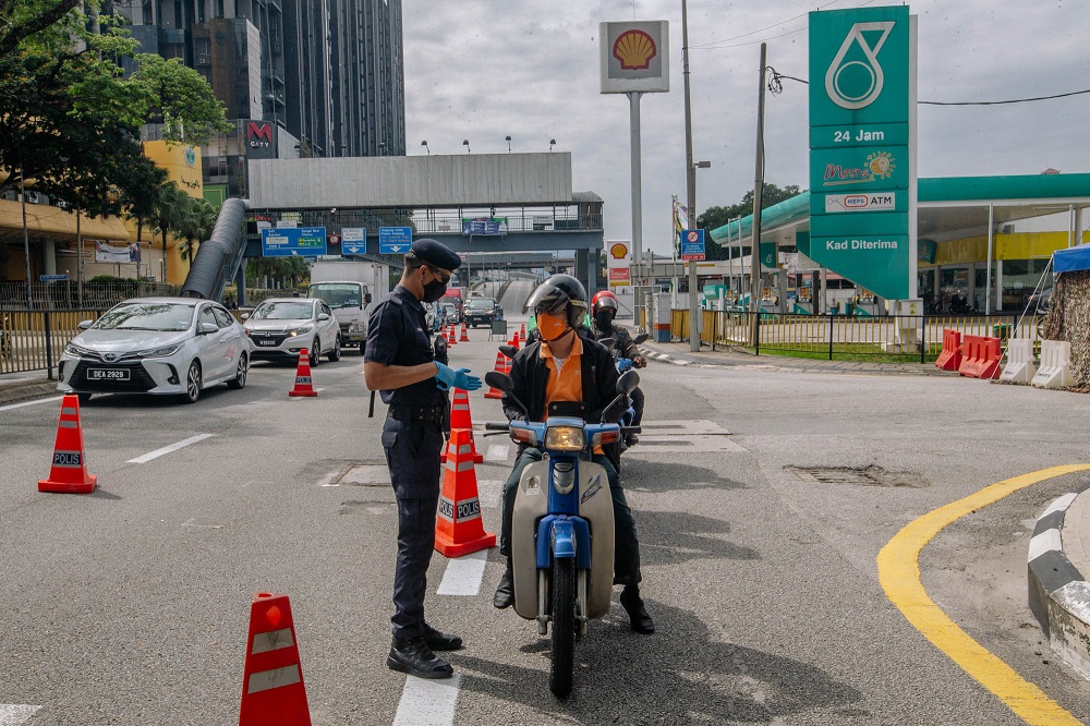 Police and army personnel conducting checks at a roadblock in Jalan Ampang during the enhanced movement control order (EMCO) July 3, 2021. u00e2u20acu2022 Picture by Firdaus Latif