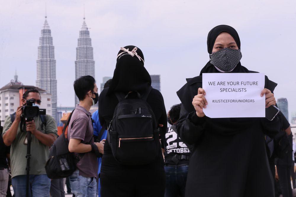 Contract doctors hold aloft placards demanding equal treatment as they go on strike at the Kuala Lumpur Hospital July 26, 2021. u00e2u20acu201d Picture by Ahmad Zamzahuri