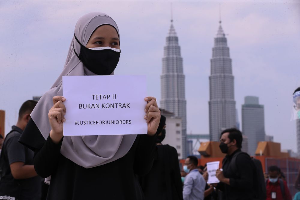 Contract doctors hold aloft placards demanding equal treatment as they go on strike at the Kuala Lumpur Hospital July 26, 2021. u00e2u20acu201d Picture by Ahmad Zamzahuri