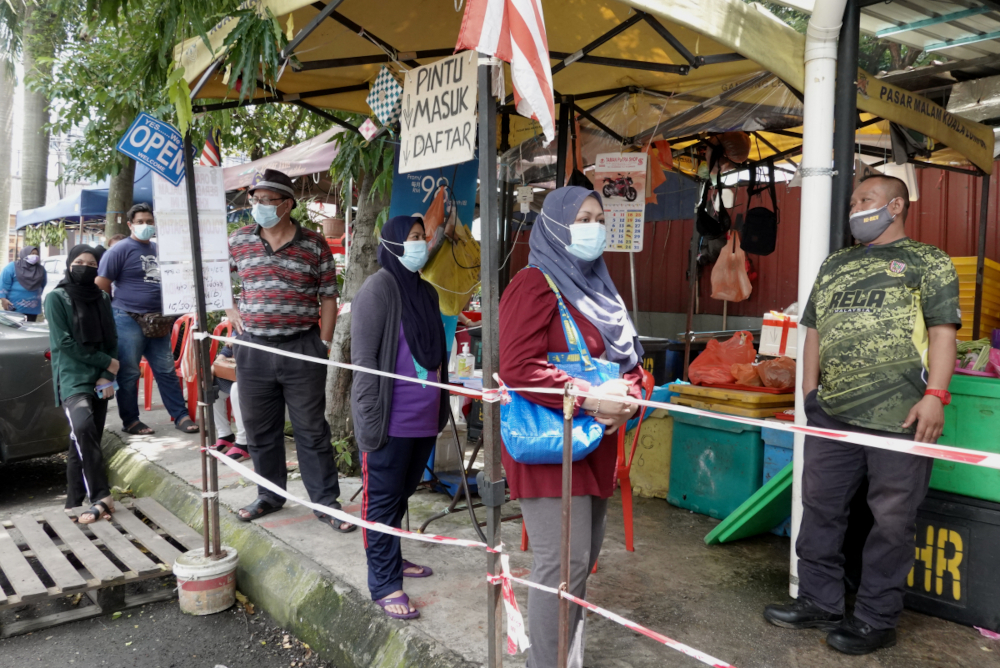 Residents of Kerinchi PPR stand in line to get provisions, July 2, 2021. u00e2u20acu201d Picture by Miera Zulyanan